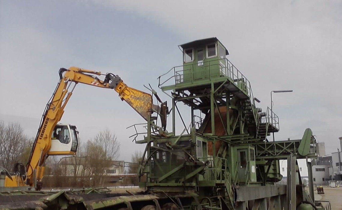Zerlegen einer Gro&szlig;maschine mit einem Bagger.