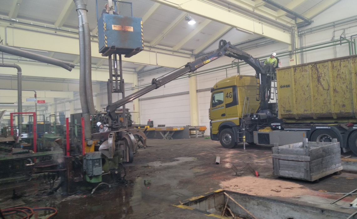 Einsatz von Hubsteiger und Kran-LKW bei der Demontage von Industrieanlagen in einer Halle.